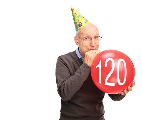 Cheerful senior blowing up a balloon